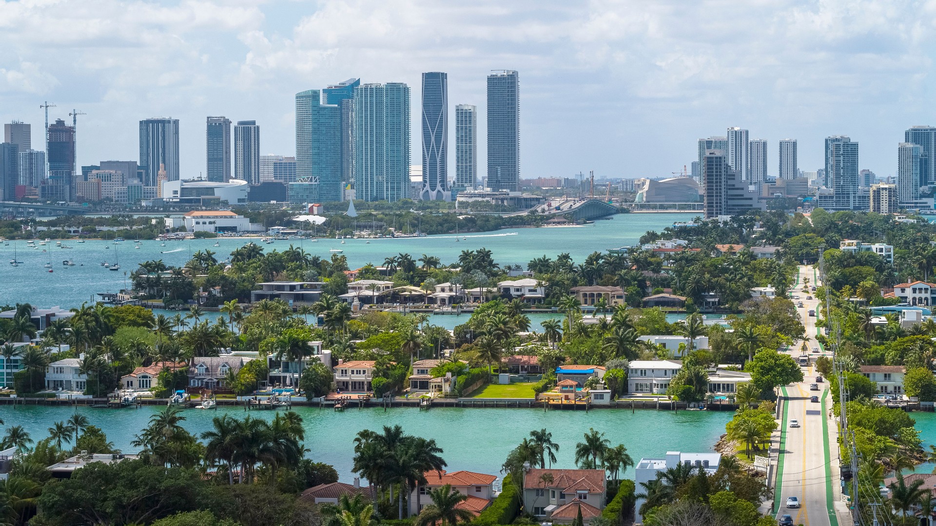 Aerial view of distant Downtown Miami over wealthy Venetian Islands on a sunny day.
